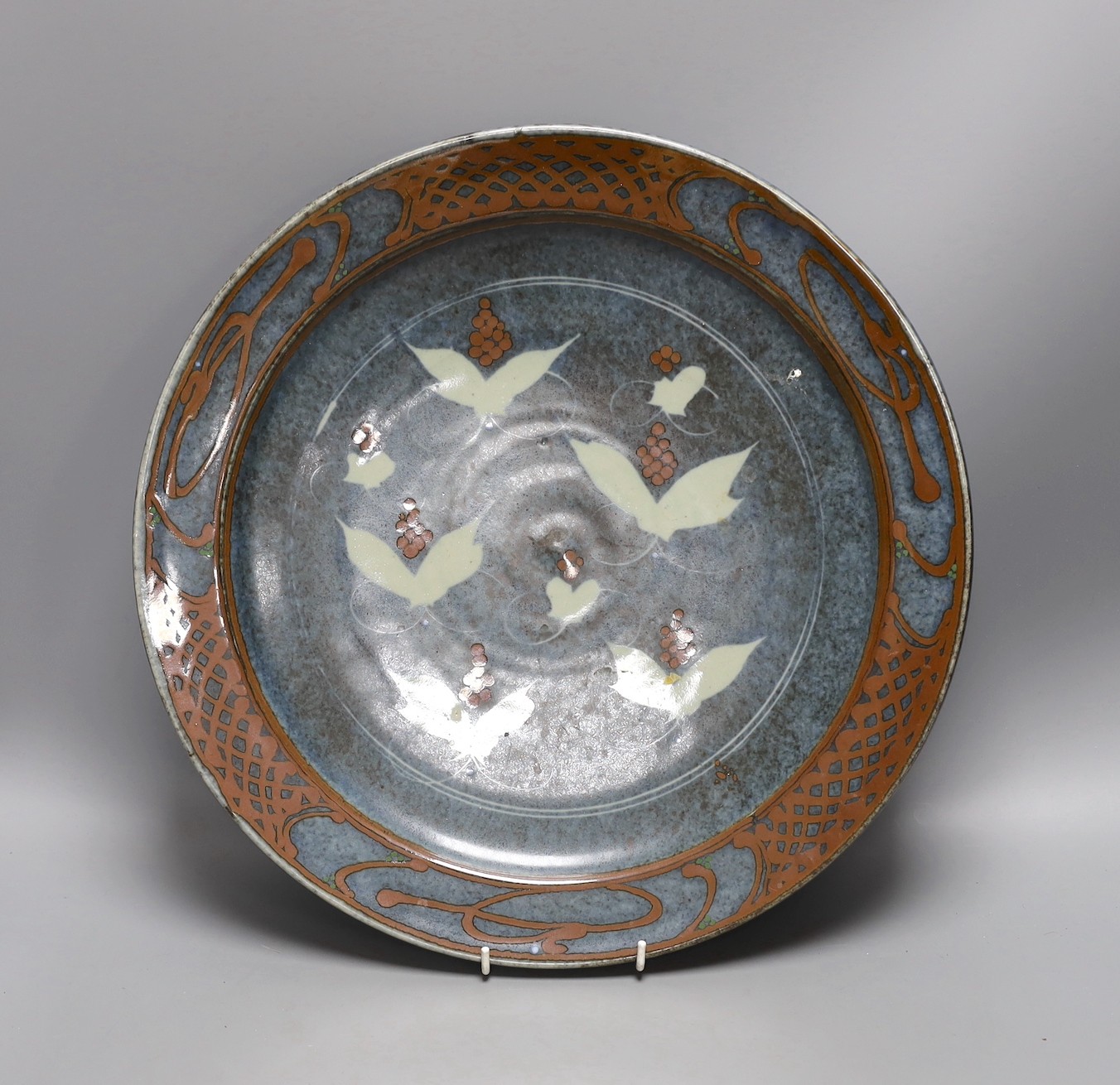 David Frith for Brookhouse Pottery - a circular stoneware charger with leaf and berry decoration. 41cm